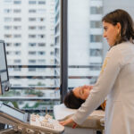 Dra. Natalia realizando ultrassom de tireoide em paciente deitada